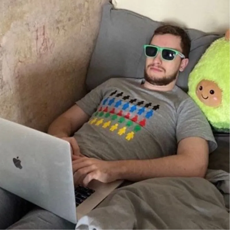 Uma pessoa da equipe do Chatfuel de óculos escuros trabalhando no sofá